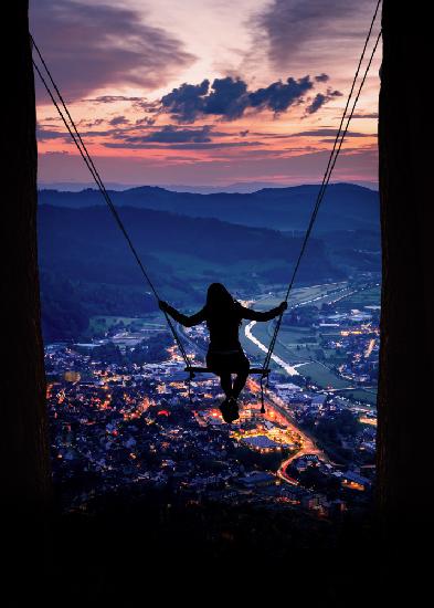 Silhouette Of A Woman On A Swing
