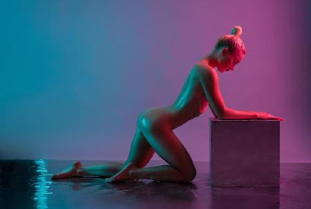 Young woman leaning on silver cube