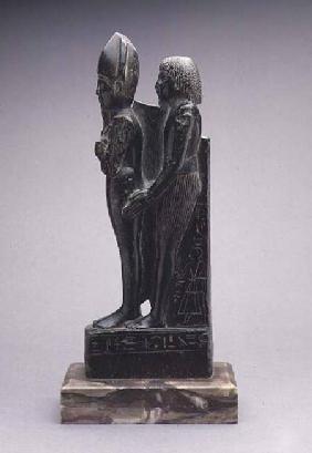 Steatite group of a man presenting a representation of Osiris