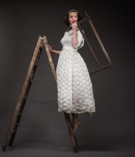 Rosa in weddingdress with saw on ladder
