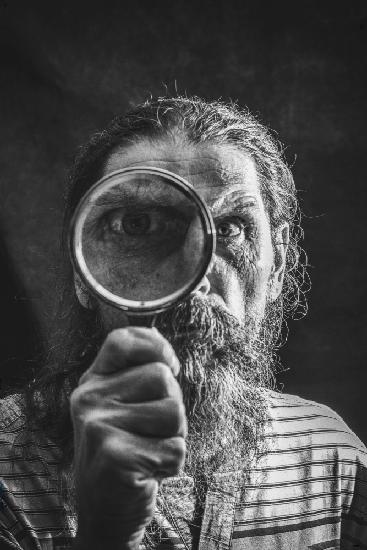 Portrait of a bearded man with a magnifying glass