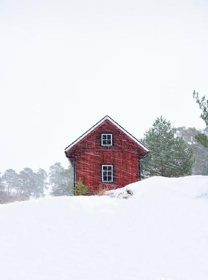 Old red house during snowstorm