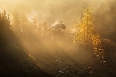 Alpine church in the morning fog