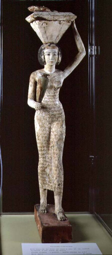 Female bearer of offerings carrying a water vase in her hand and a vessel on her head a Egizi