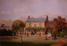 Young women practising archery on the lawn of a country house