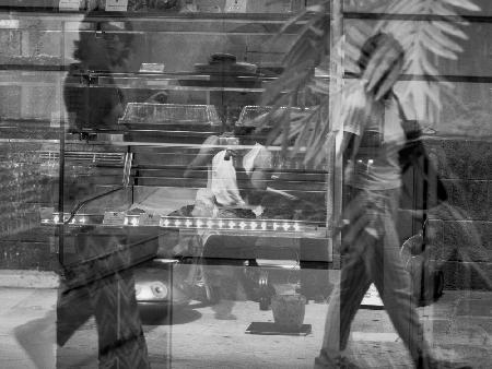 Street artist reflected in the shop window