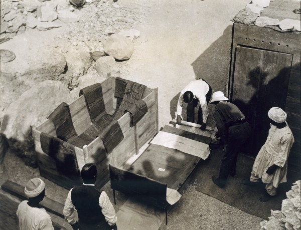 Moving the centre portion of one of the beds or couches from the Tomb of Tutankhamun, Valley of the  a Harry Burton