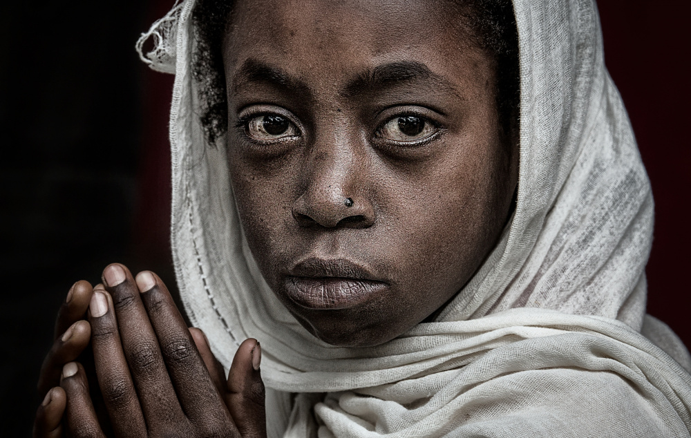 Ethiopian girl praying at a religious ceremony. a Joxe Inazio Kuesta Garmendia