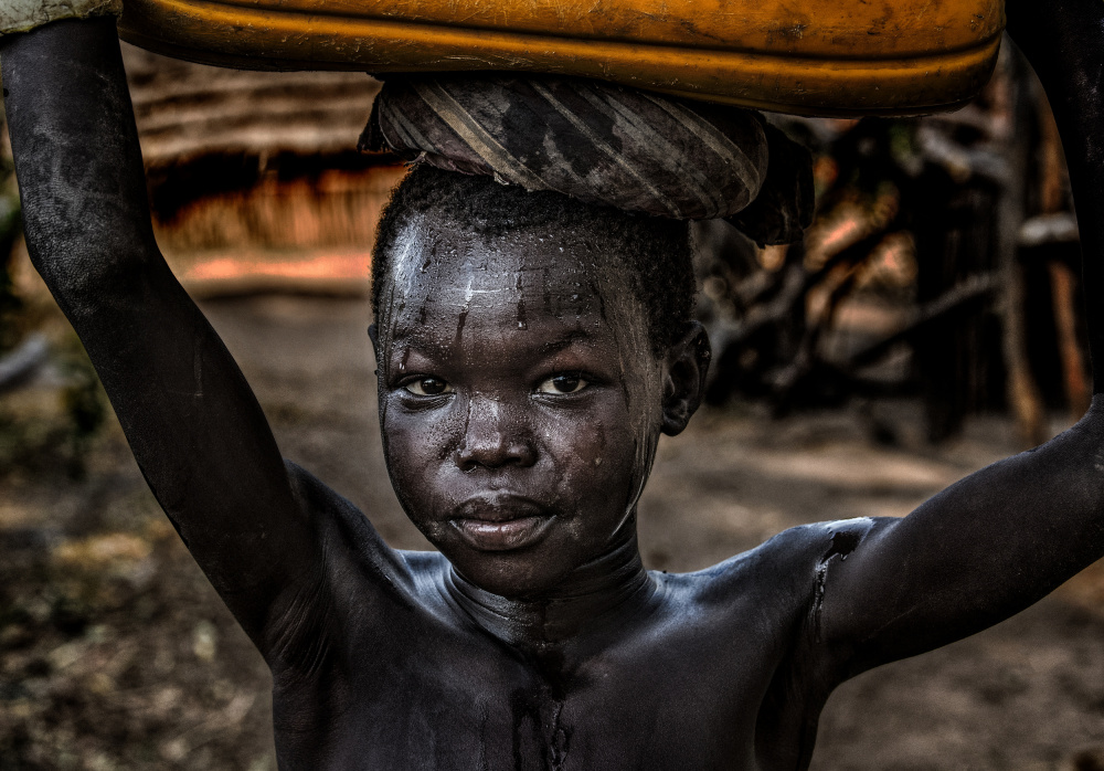 South sudanian child carrying a water containera a Joxe Inazio Kuesta Garmendia