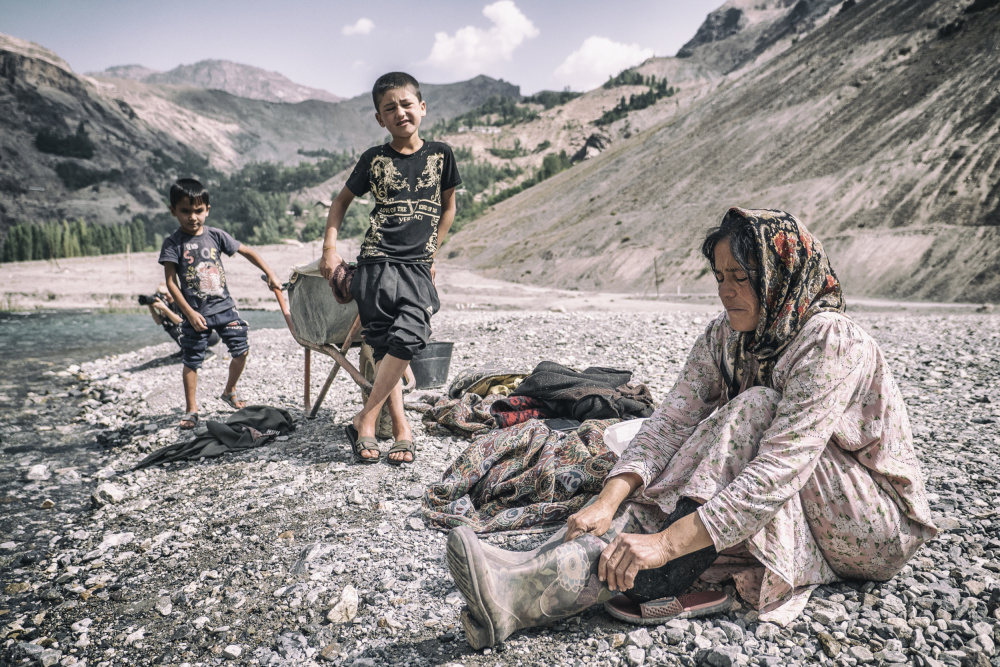 A Tajik woman is preparing to wash in the stream a Marcel Rebro