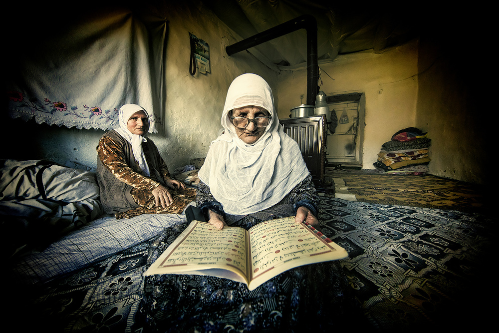 The old woman is reading the Koran. a Mehmet Çetin