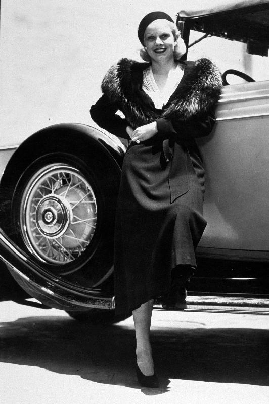 American Actress Jean Harlow posing near a car a 