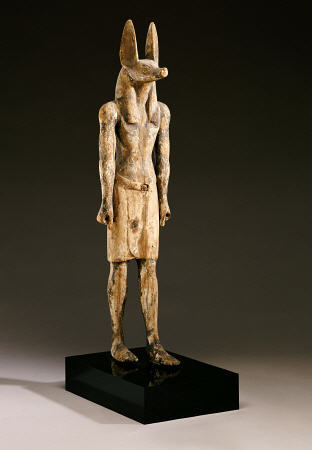An Egyptian Wood Figure Of A Jackal-Headed Deity a 