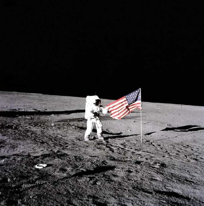 Apollo 12 Astronaut Charles Pete Conrad stands beside the United States flag after is was unfurled o a 
