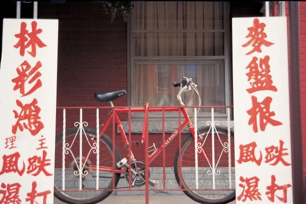 Bicycle at metal bars with Chinese board , Singapore (photo)  a 