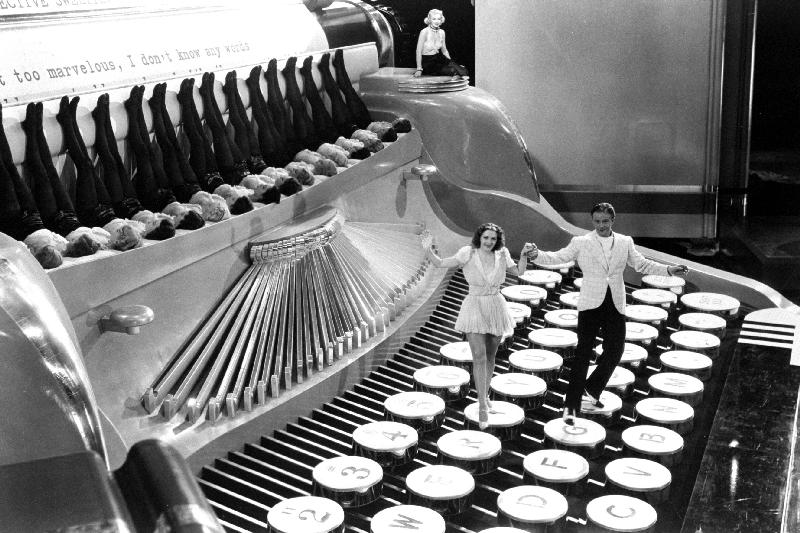 Couple dancing on the key of a giant typewriter, keys are leg of dancers, musical a 