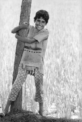 Kashmiri boy holding tree trunk (b/w photo) 