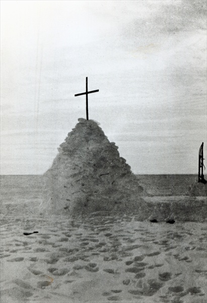 The tomb of Scott of the Antarctic and his companions, Bowers and Wilson, marked by a mound of snow, a 