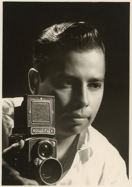 Orlando Suero portrait with Rolleiflex camera, c a Orlando Suero