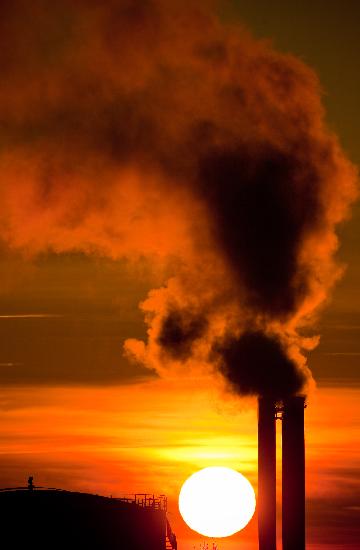 Qualmende Schornsteine im Sonnenaufgang a Patrick Pleul