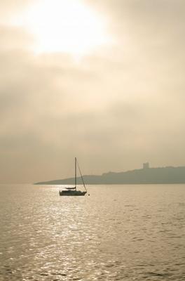 Segelboot in der Bucht im Gegenlicht