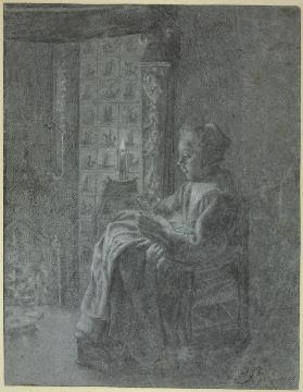 Sitzende junge Frau bei Kerzenschein mit einem Glas in der Hand