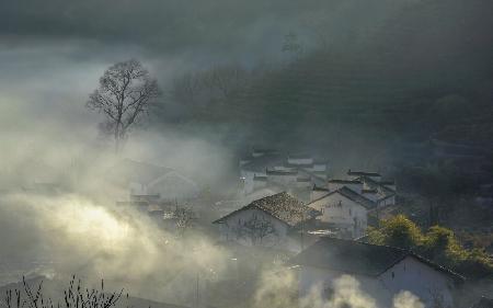 The Village with Curling up Smoke in Morning Mist