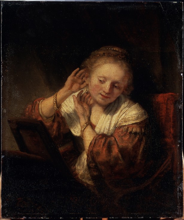 Young Woman trying on Earrings a Rembrandt van Rijn