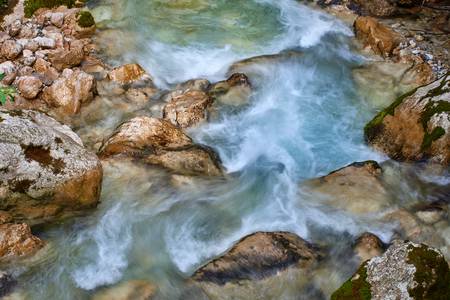 Fliessendes Wasser in einem Bachbett mit Steinen