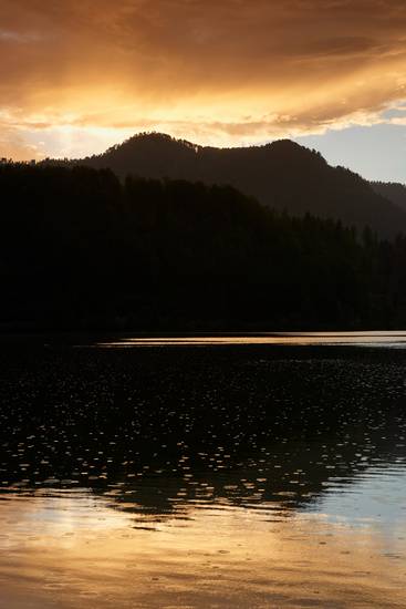 Romantisches Abendrot mit Wolkenstimmung und Bergsilhouette am Almsee