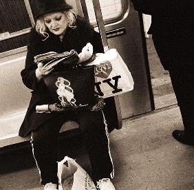 Woman reading on a subway with a Marilyn Monroe purse and an ''I Love New York'' bag, 2004 (b/w phot